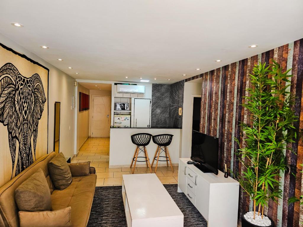 a living room with a couch and a tv at 2 BEDROOM Condo -IPANEMA in Rio de Janeiro