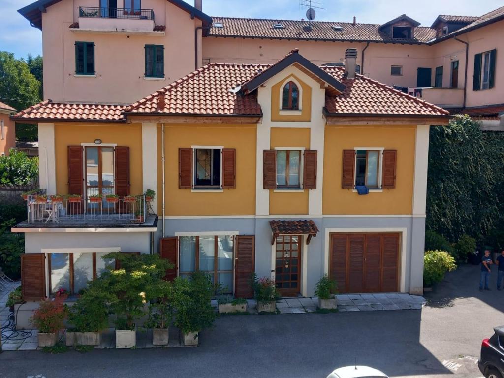 a large yellow house with a red roof at Dimora Marisa in Albiate