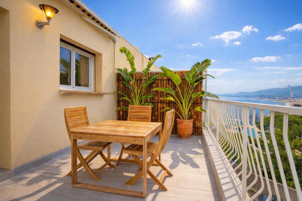 a table and chairs on a balcony with a view of the ocean at Etrave in Toulon