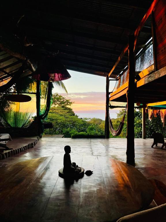 a person sitting on the floor of a building at Open spacious house with stunning Peninsula view in Pavones