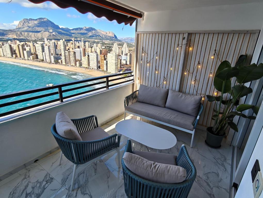 a balcony with a couch and chairs and a table at Sea&Skyline Suites Benidorm in Benidorm