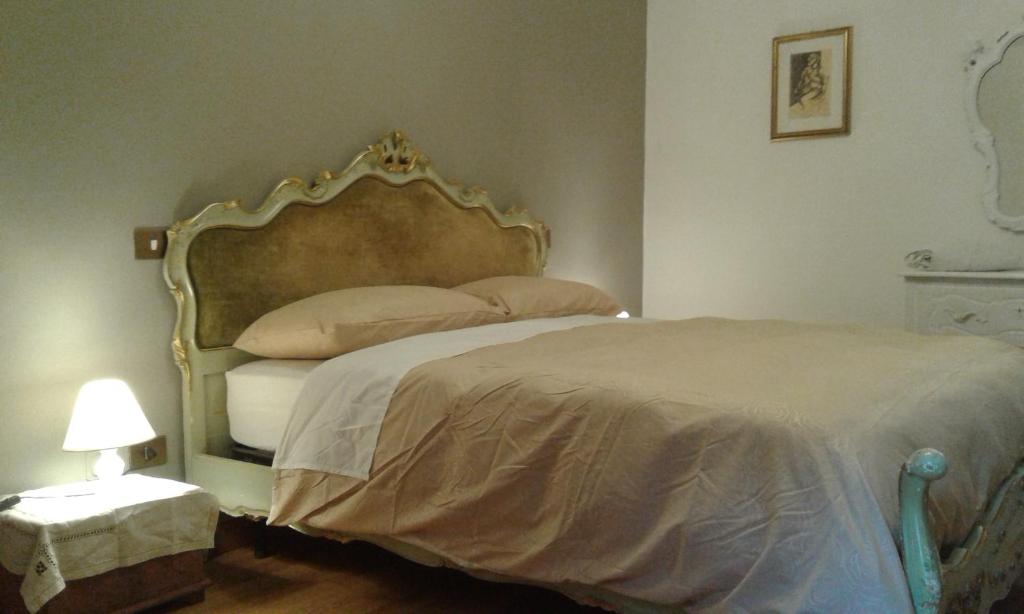 a bedroom with a large bed with a gold headboard at casa vacanze crochi in Viterbo