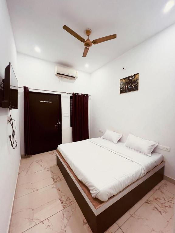 a bedroom with a bed with a ceiling fan at Vasudeva Villas in Udaipur