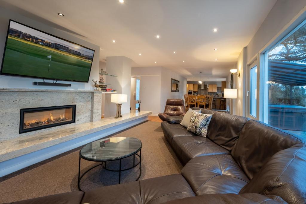 a living room with a couch and a fireplace at The Fairways House in Glenrothes