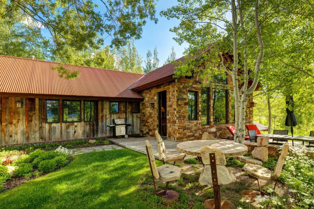 a stone house with a table and chairs in the yard at Abode at Teton Manor in Jackson