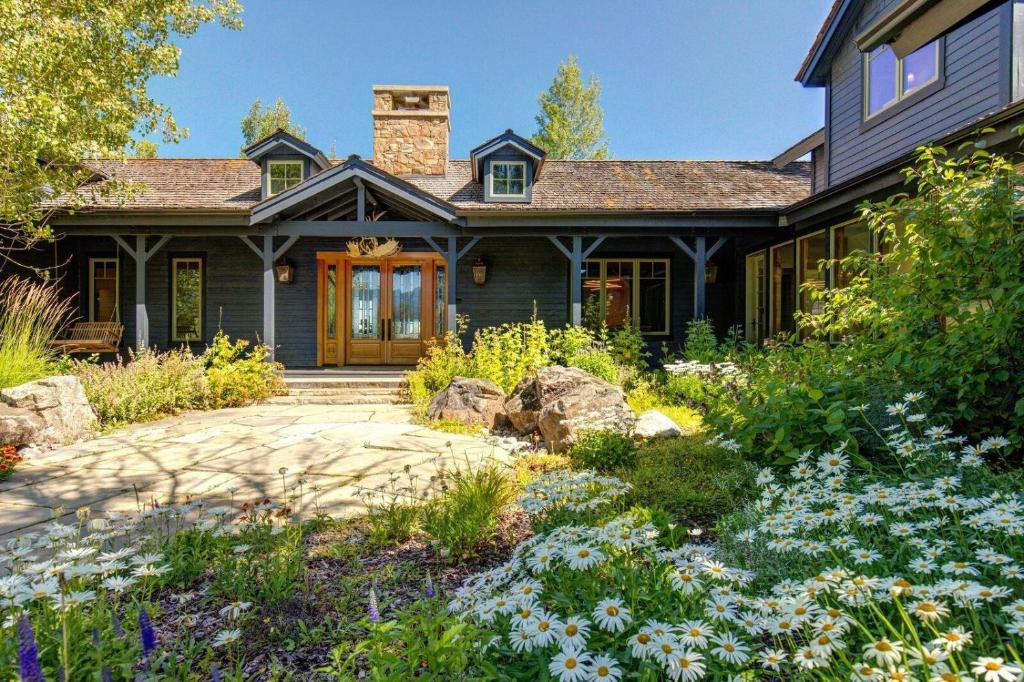 a black house with a yard with flowers at Abode at Open Meadows in Wilson