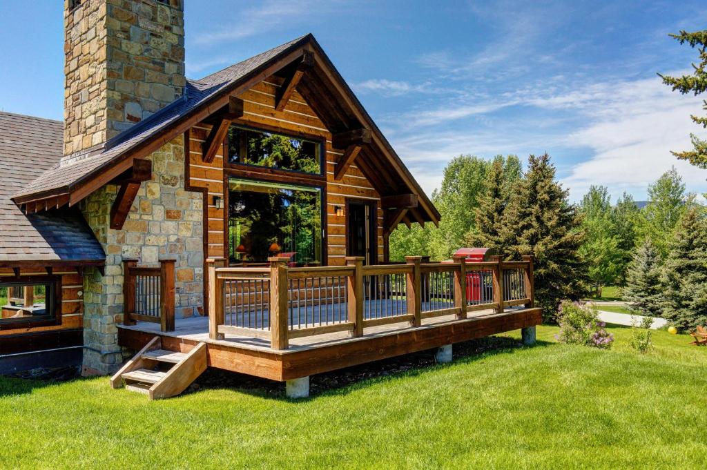 a log cabin with a large deck in the yard at Abode at Skyline in Jackson
