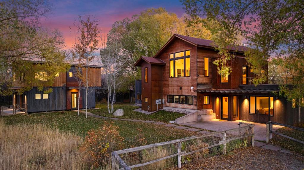a large wooden house with a fence in front of it at Abode at Alpenglow in Wilson