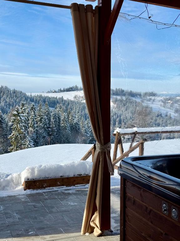 a window with a view of a snow covered mountain at WierchoHouse - domek z jacuzzi in Groń