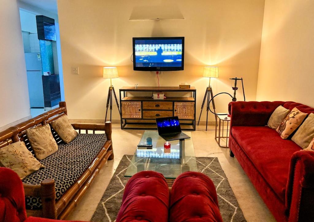 a living room with two couches and a flat screen tv at Sparra Homes in Gurgaon
