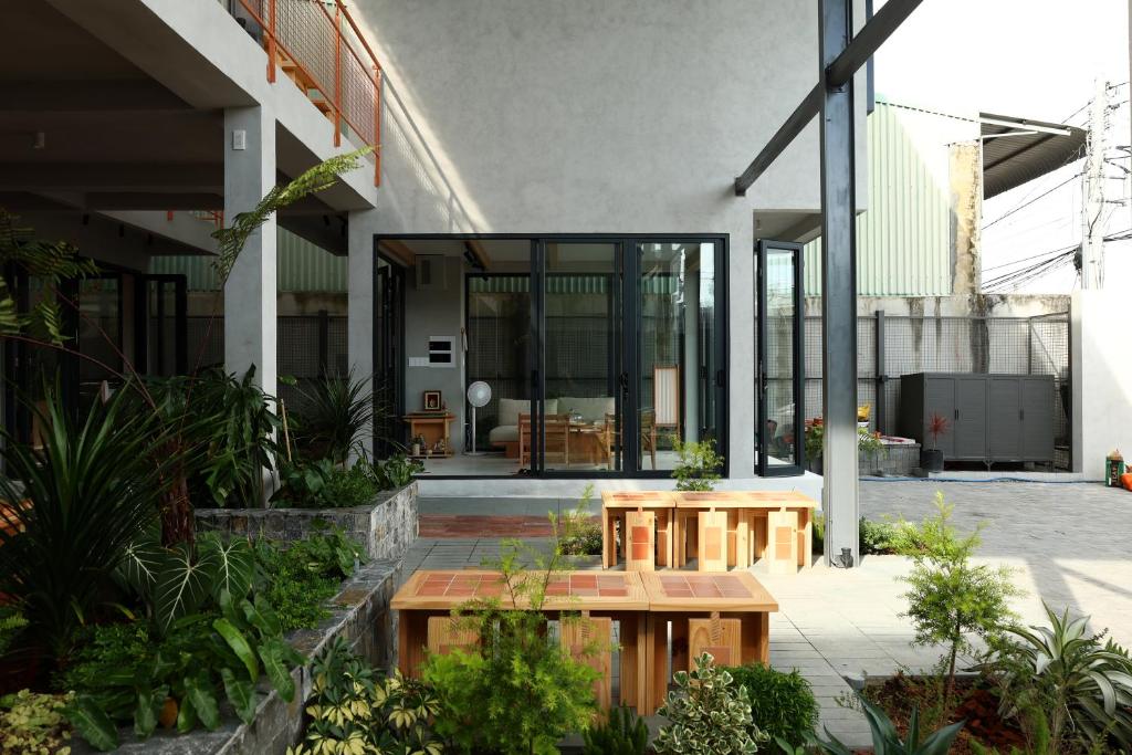 a building with two wooden tables in a courtyard at Hale Homestay in Ấp Thanh Sơn (1)