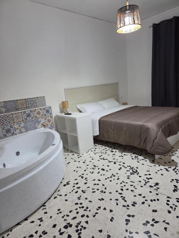 a bedroom with a bed and a bath tub next to a bed istg at Happy House Herculaneum in Ercolano