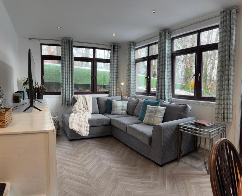 a living room with a couch and some windows at The Glebe in Fort William