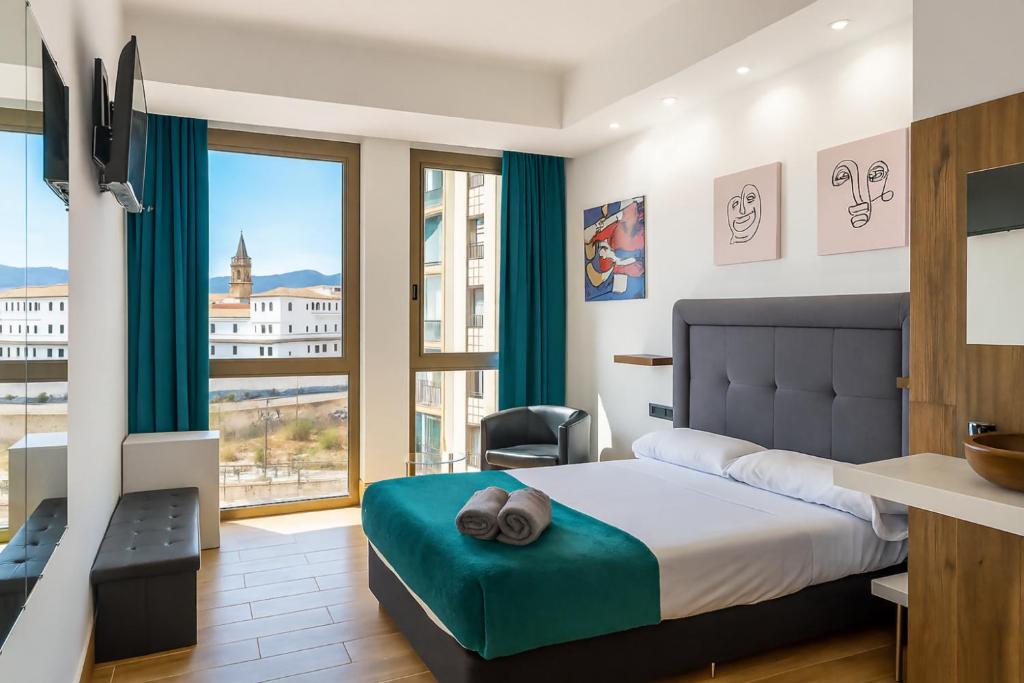 a bedroom with a bed and a large window at Ilustre Rooms Malaga in Málaga