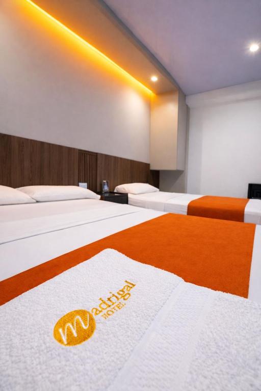 a hotel room with two beds with a welcome sign on it at Hotel Madrigal in Portoviejo