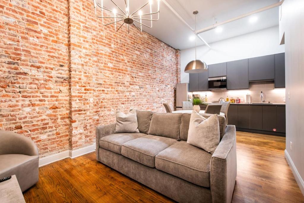 a living room with a couch and a brick wall at Hollyhock Suite 403 in Louisville