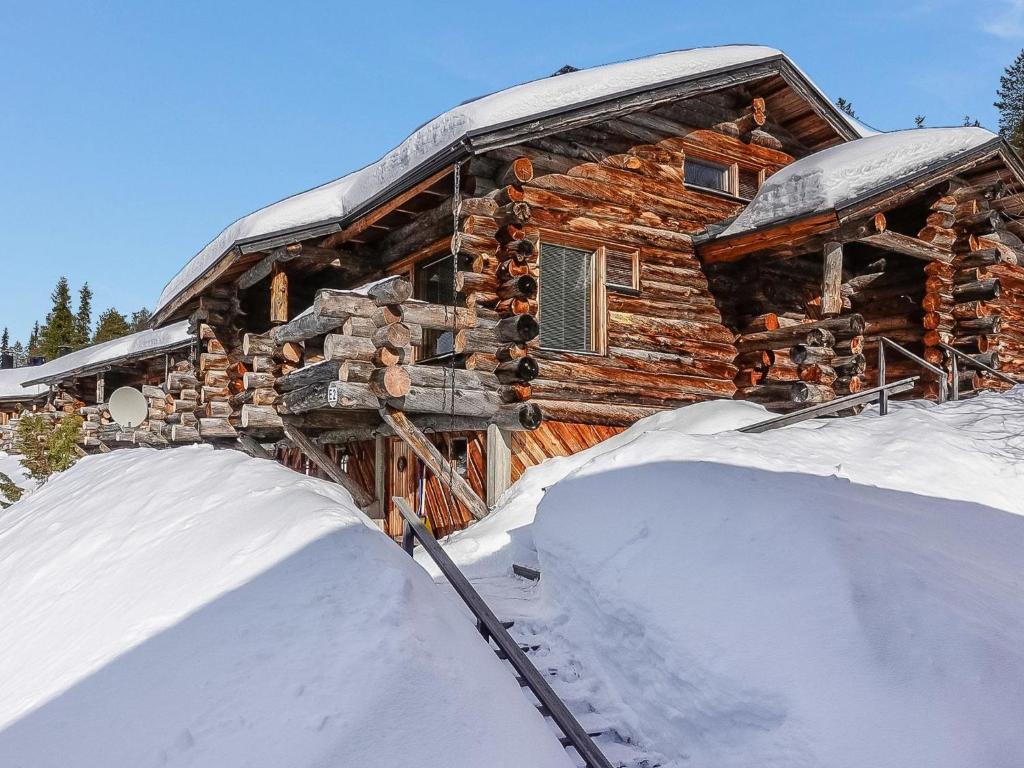a log cabin in the snow in front at Holiday Home Sallanhelmi e2 by Interhome in Salla