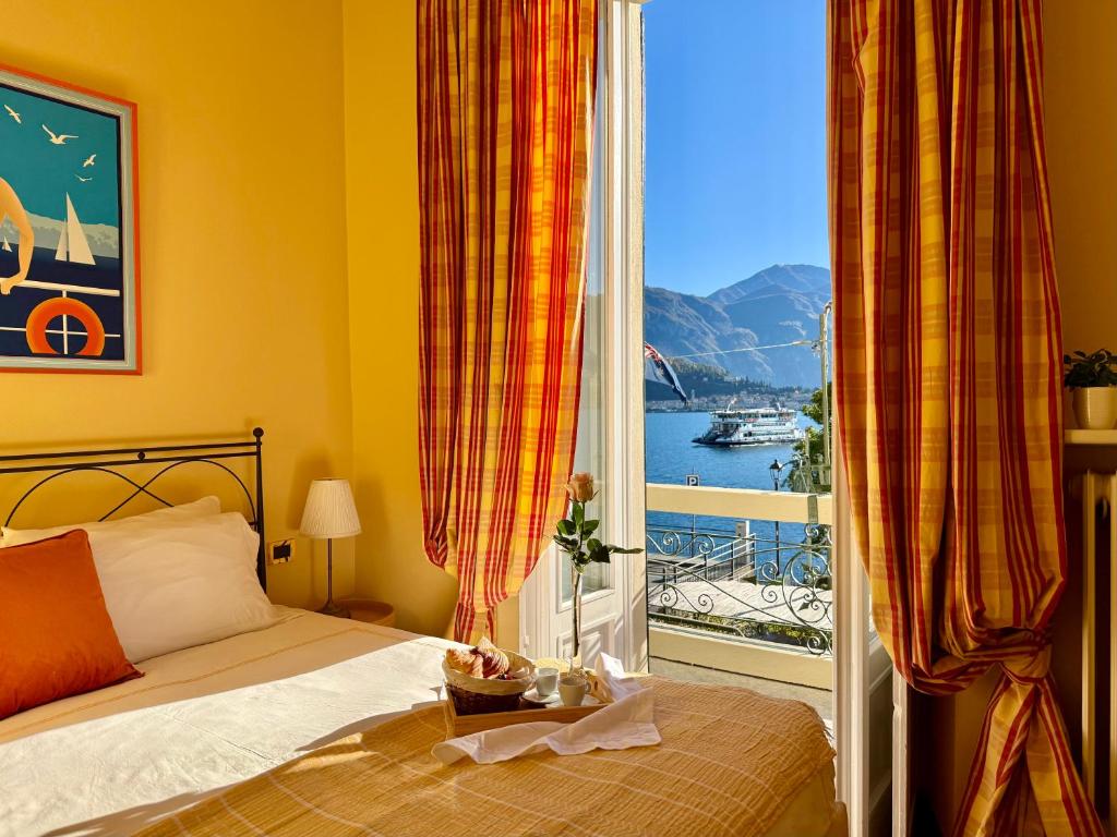 a bedroom with a bed and a large window at BELLE ILE LAKE VIEW SUITE in Griante Cadenabbia