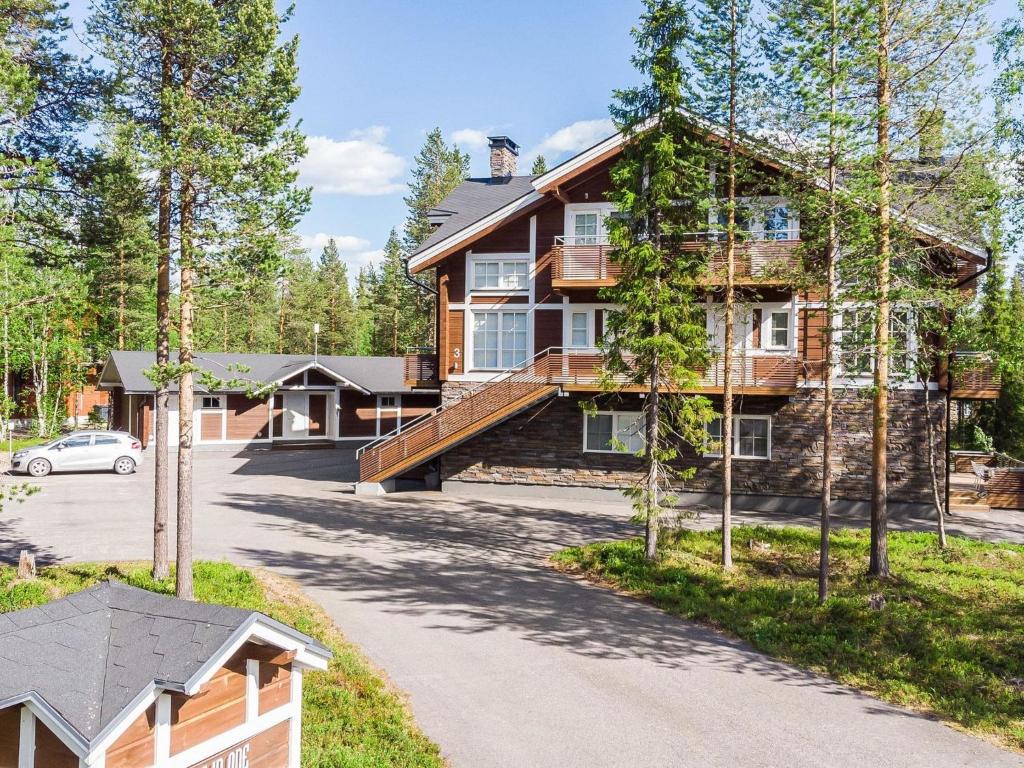 a house in the woods with a driveway at Holiday Home Golfväylä 3b - golf-osakkeen käyttöoikeus by Interhome in Levi