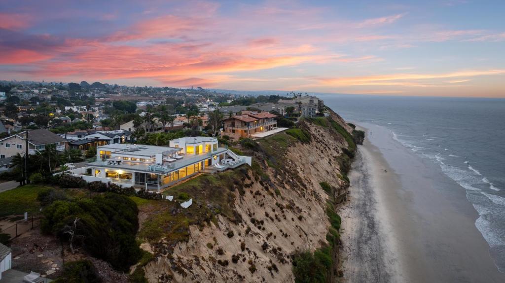 a house on a cliff next to the ocean at Encinitas Shores - Beachfront, Ocean View & Patio in Encinitas