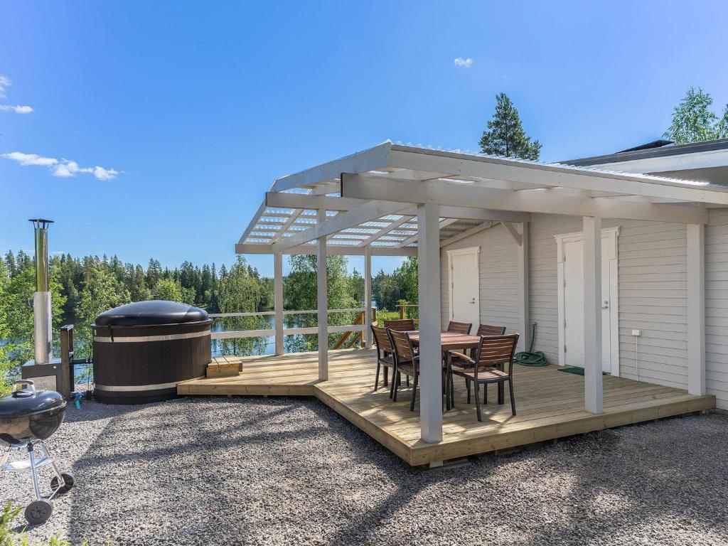 a pavilion with a table and chairs on a deck at Holiday Home Valonsäde by Interhome in Valkeala