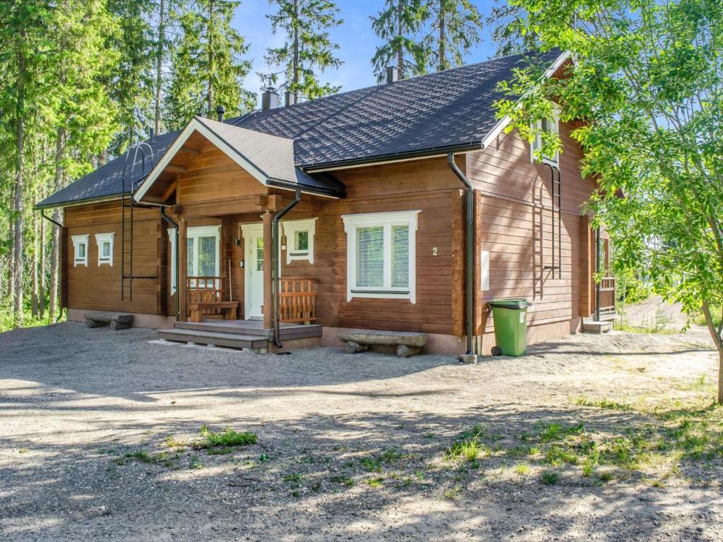 a small wooden house in the woods with a porch at Holiday Home Villa valo by Interhome in Kolinkylä