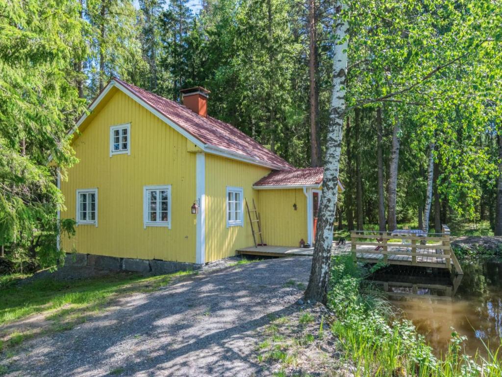 a yellow house in the middle of a forest at Holiday Home Piispasen torppa by Interhome in Alastaro