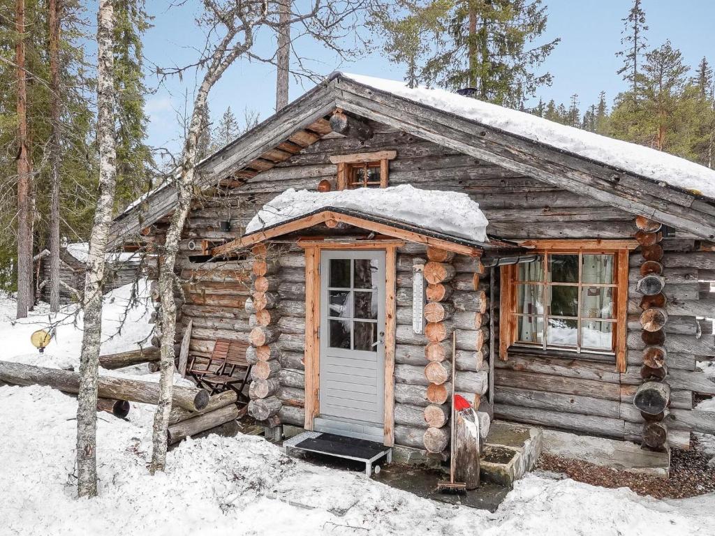 a log cabin with snow on the roof at Holiday Home Kelokota by Interhome in Salla