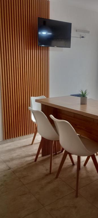 a table and chairs with a television on a wall at Duplex Atenea in Chivilcoy