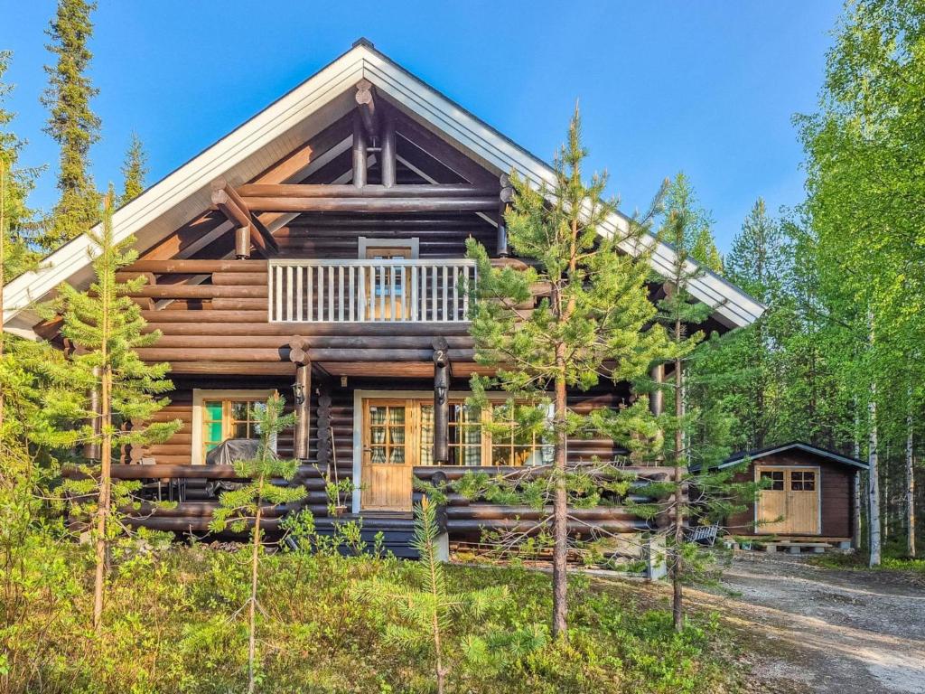a log cabin in the woods with a wrap around porch at Holiday Home Luppokero by Interhome in Salla