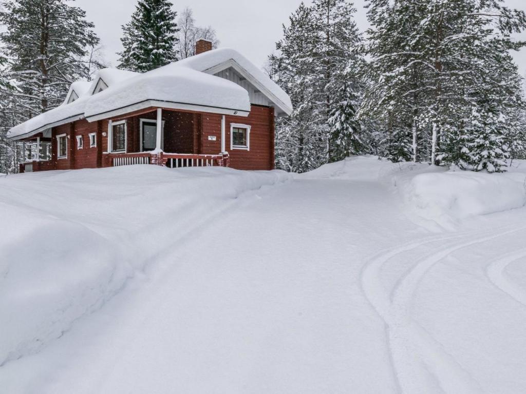 a house covered in snow next to a driveway at Holiday Home Lomapesä 10a by Interhome in Kotila