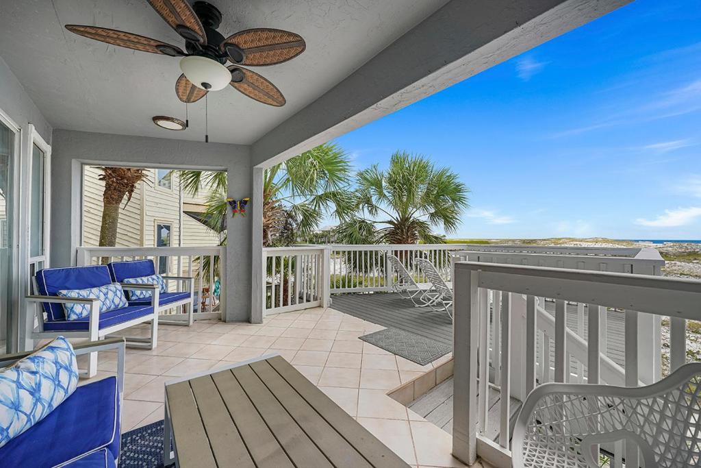 a porch with chairs and a ceiling fan at Family Tides - Beachfront Pet-Friendly Duplex in Destin
