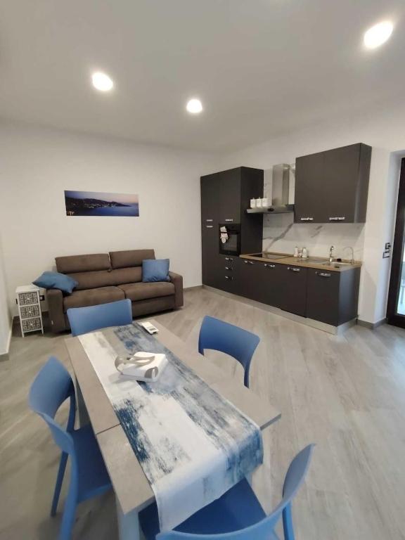 a living room with a table and blue chairs at 80062 Cute House in Meta