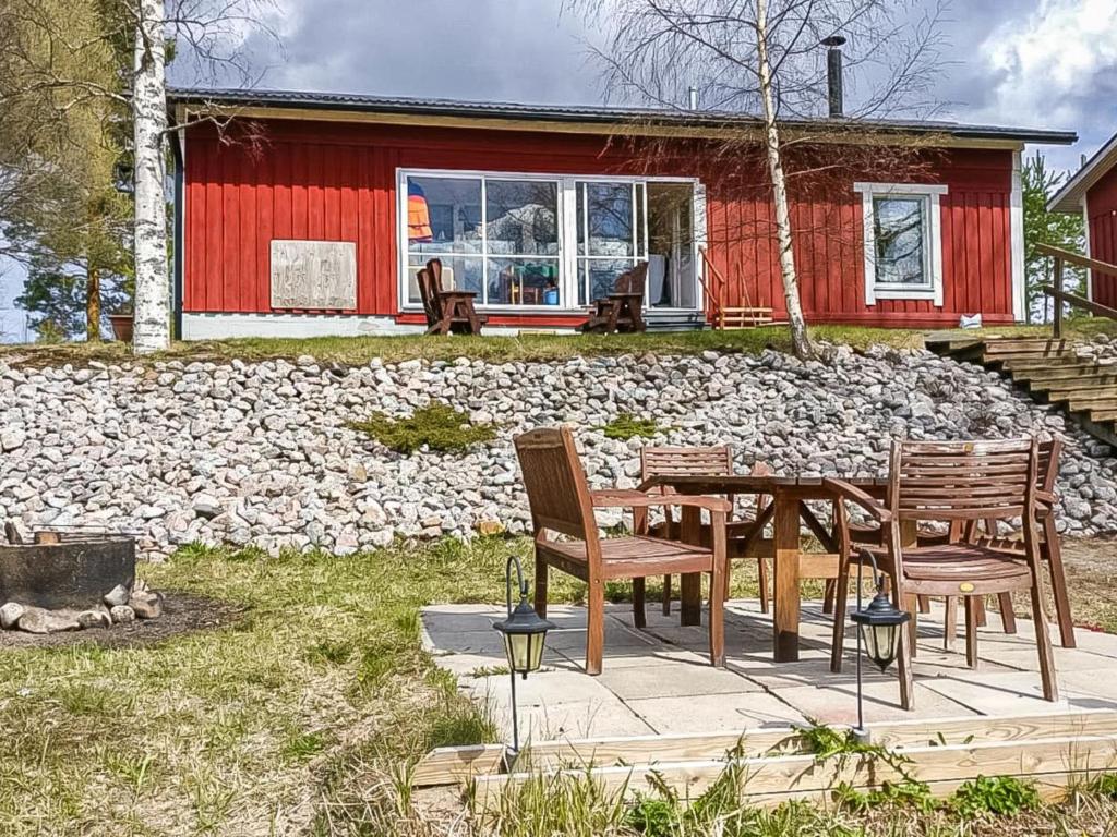 a table and chairs in front of a red house at Holiday Home Kivirinne by Interhome in Äijälä
