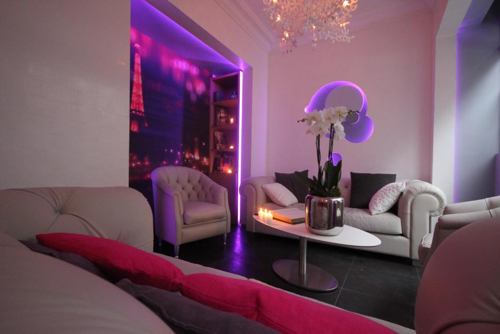 una sala de estar con 2 sofás y una mesa con flores en Hôtel Lumières Montmartre Paris, en París