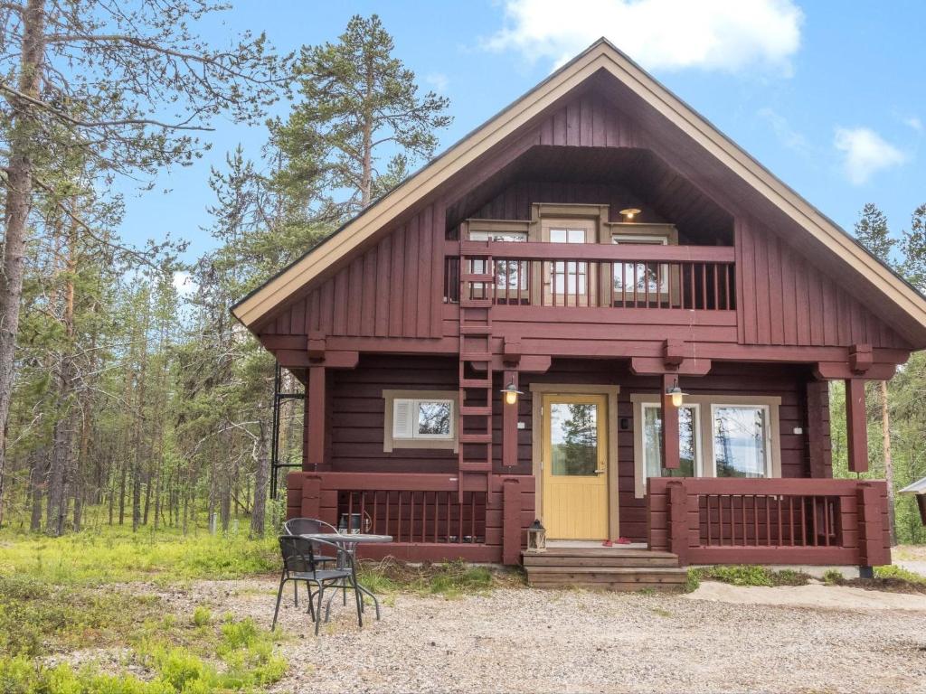a cabin in the woods with a yellow door at Holiday Home Kätkä by Interhome in Kotkasuvanto