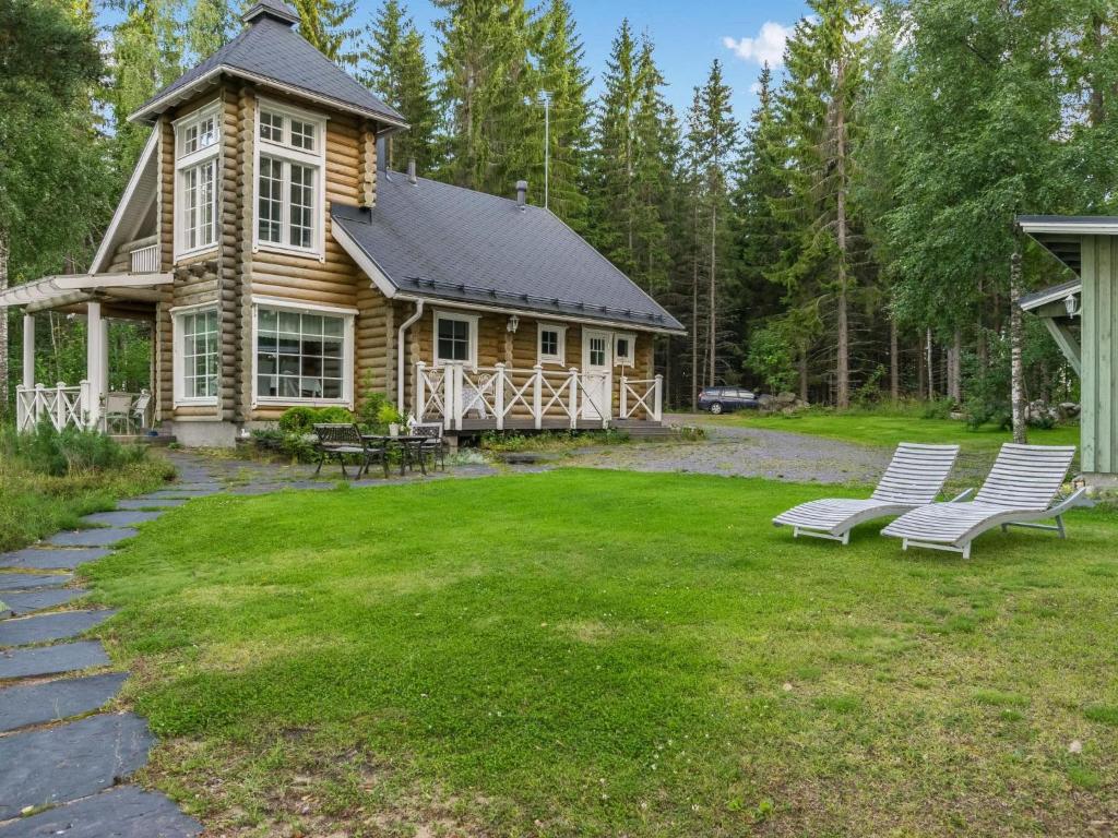 a log cabin with two benches in the yard at Holiday Home Torniniemi by Interhome in Hiukkajoki