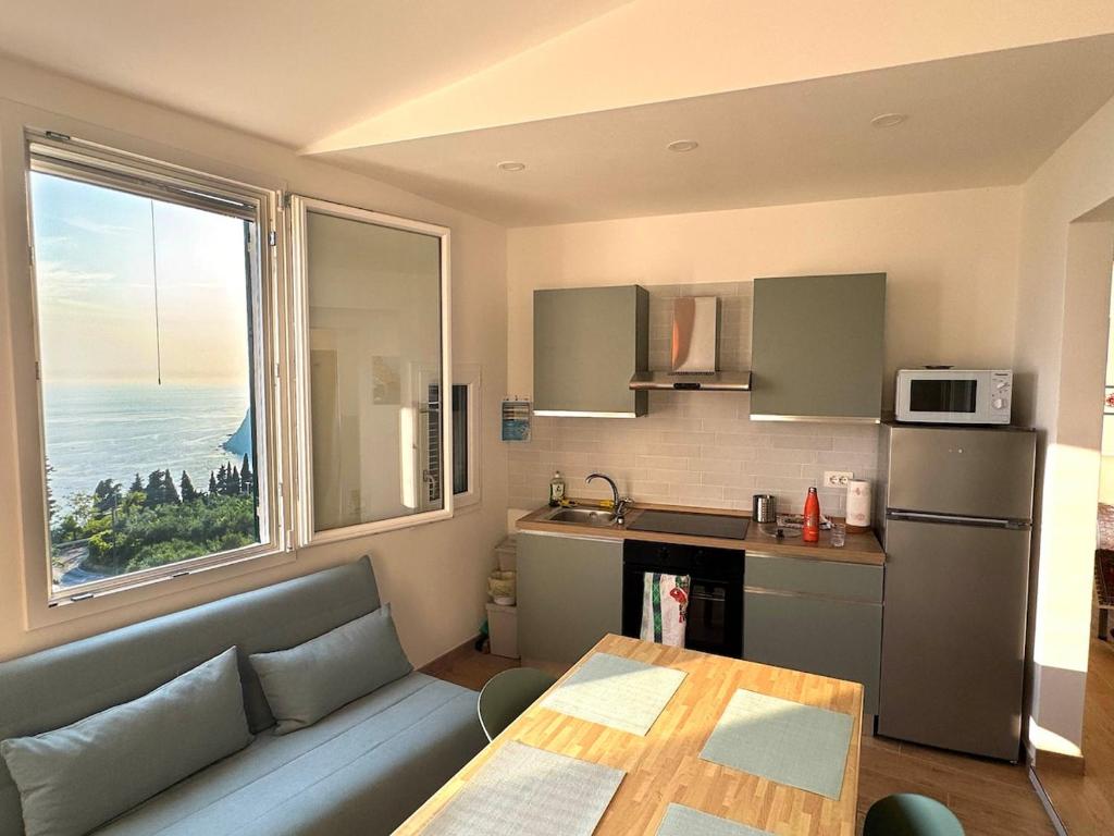 a kitchen with a couch and a table and a window at Finestre sul mare in Framura