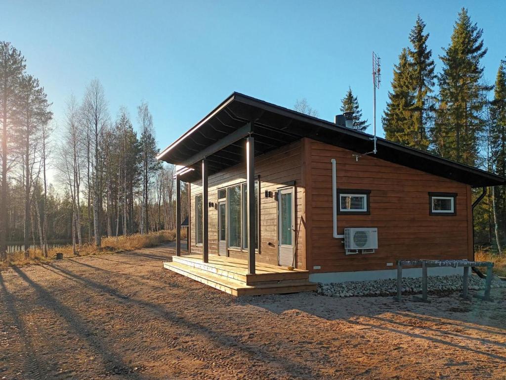 a small wooden cabin in the middle of a forest at Holiday Home Jolmalompolo by Interhome in Raanujärvi