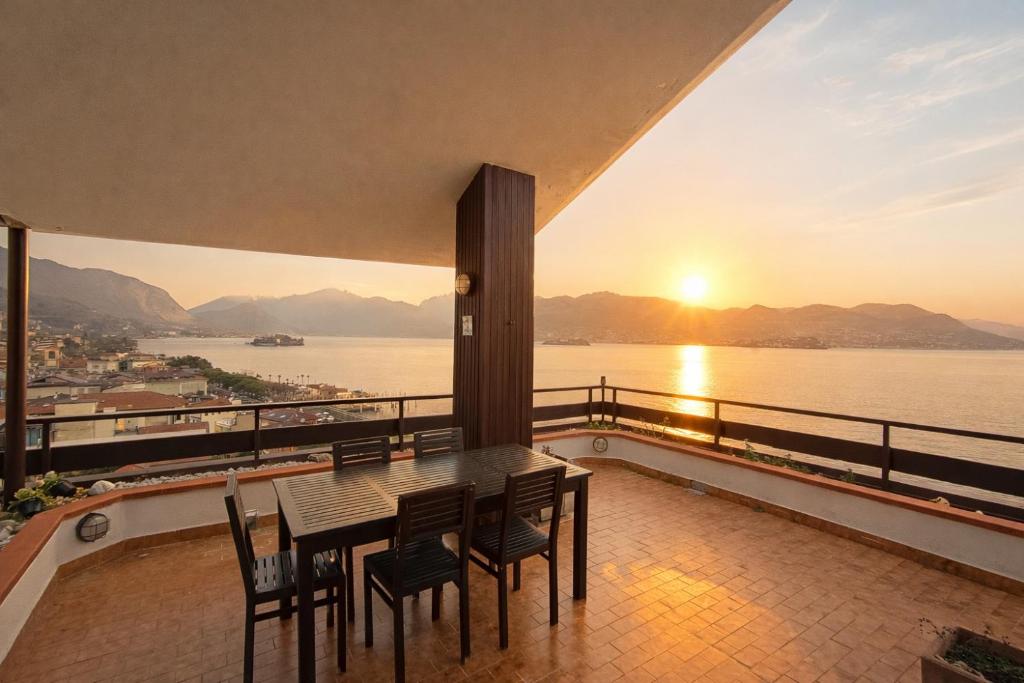 a table and chairs on a balcony with a view of the water at Suite Dream in Stresa