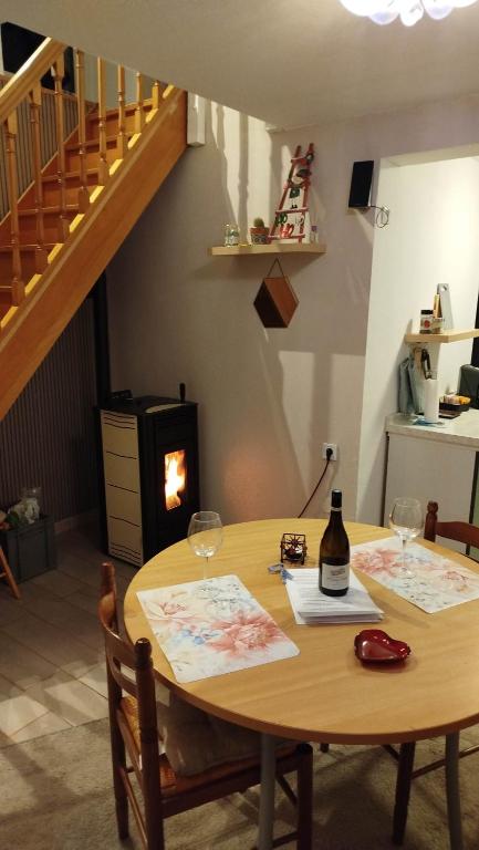 a table with two wine glasses and a staircase at le petit cosy terrasse et spa in Petersbach