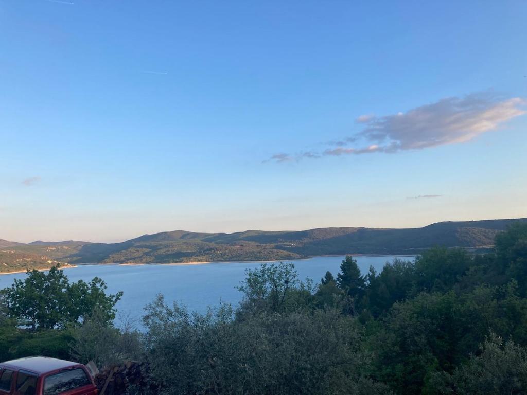 a view of a lake with a car parked next to it at Appartement avec vue sur le Lac in Sainte-Croix-de-Verdon