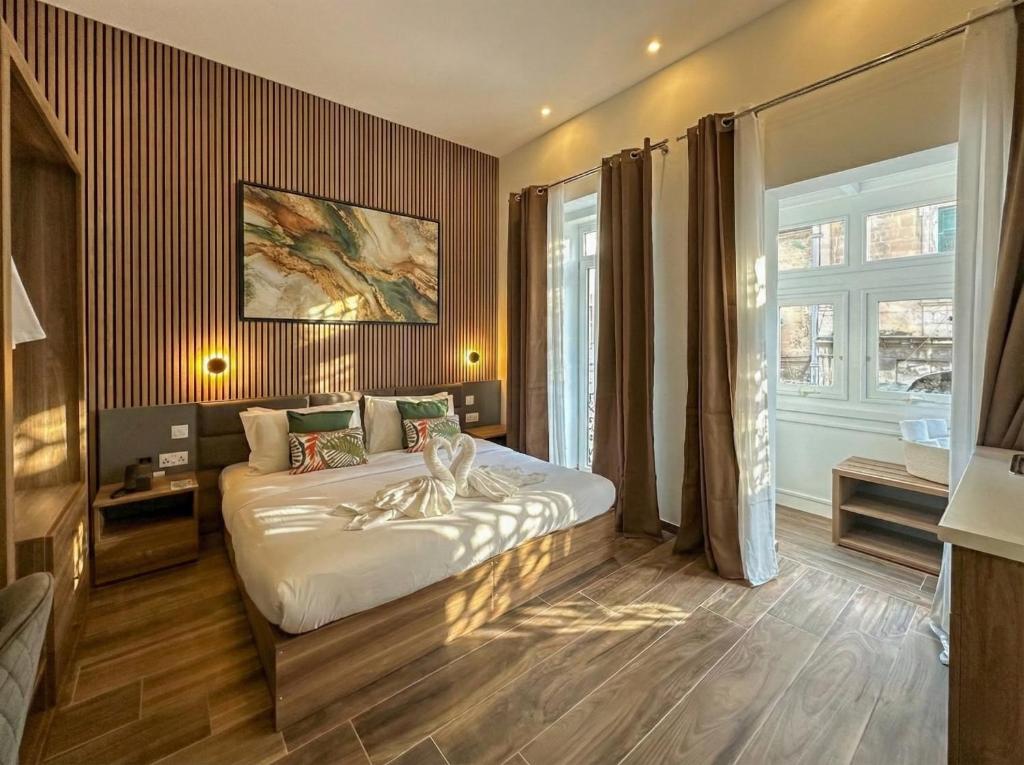a bedroom with a bed and a large window at Kappuccini Hill boutique hotel - By Tritoni Hotels in Il-Furjana