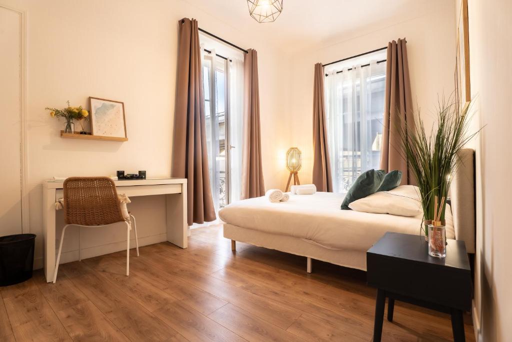 a bedroom with a bed and a desk and windows at Chambre 3 La Madalena in Nice