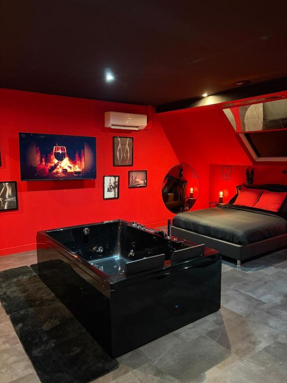 ein rotes Zimmer mit Whirlpool und Bett in der Unterkunft Spa2Luxe - L Interdite in Saint-Quentin