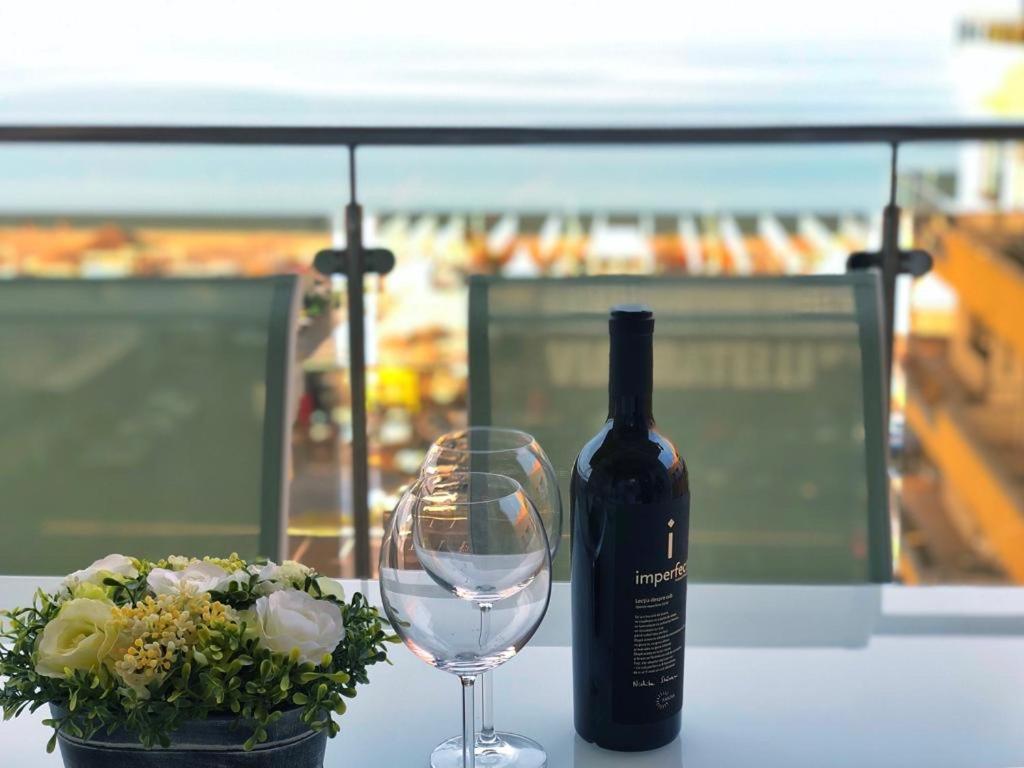 a bottle of wine and a glass on a table at Summerlad Mamaia Beach in Mamaia