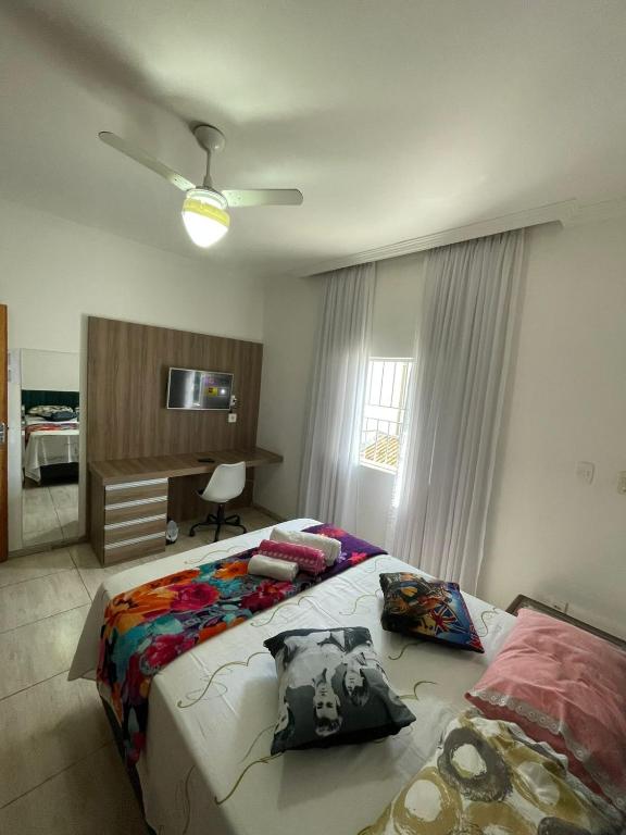 a bedroom with a bed and a desk and a window at Hostel Castelo in Belo Horizonte