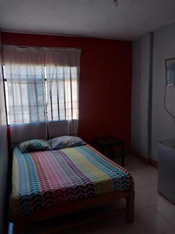 a bed in a room with a window and a bed sidx sidx sidx at Casa Ibañez in Talara