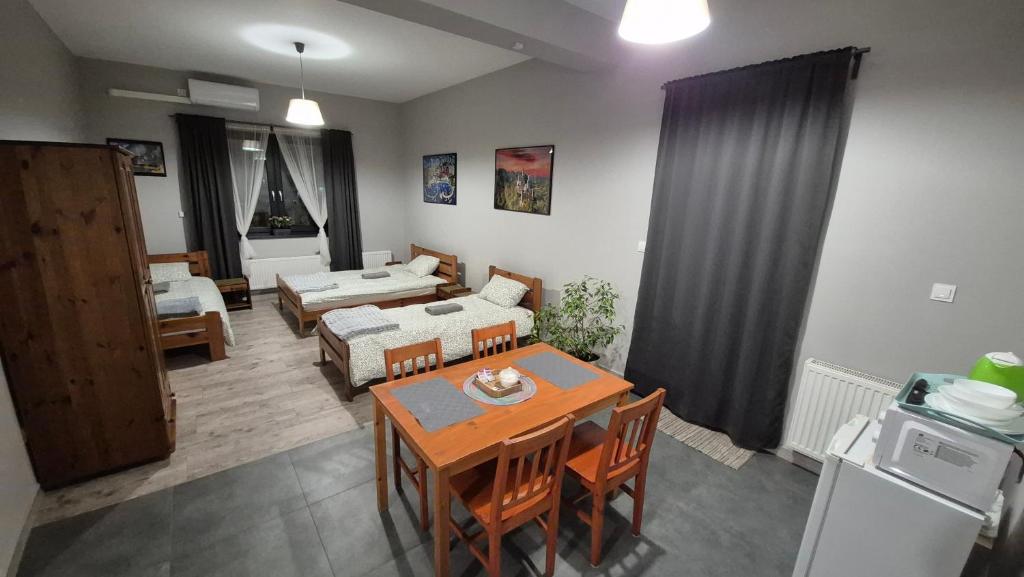 a living room with a table and chairs and a living room at KEISA APARTRooms in Nowy Sącz