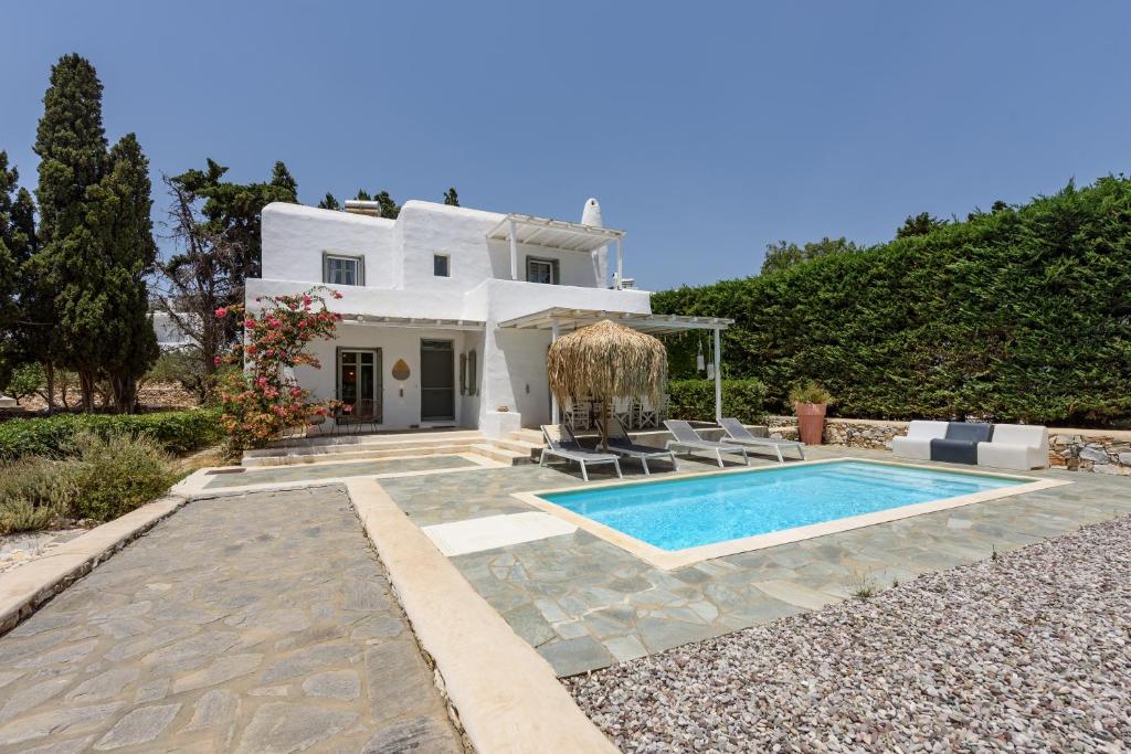 a white house with a swimming pool in front of it at Sun Drop 1 with private pool, 5-min walk to Drios beach in Drios